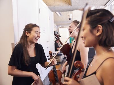 String chamber players laughing while waiting to go on stage